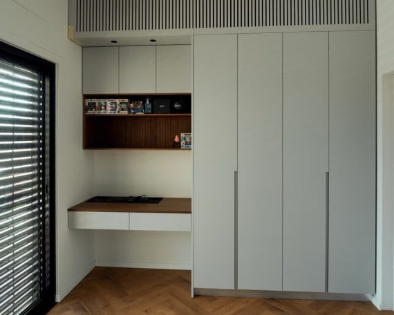 Sleek modern kitchen design with white cabinets and wooden elements.